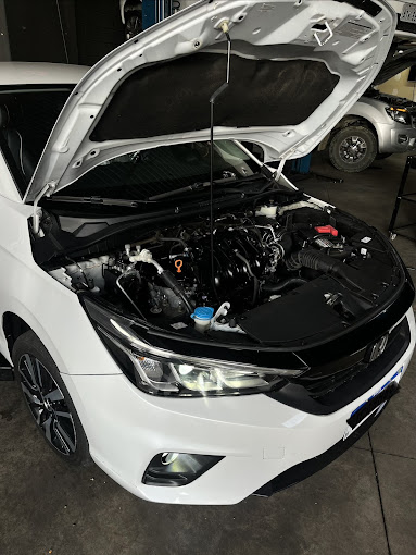 Carro com capô aberto em manutenção na oficina DEZONE